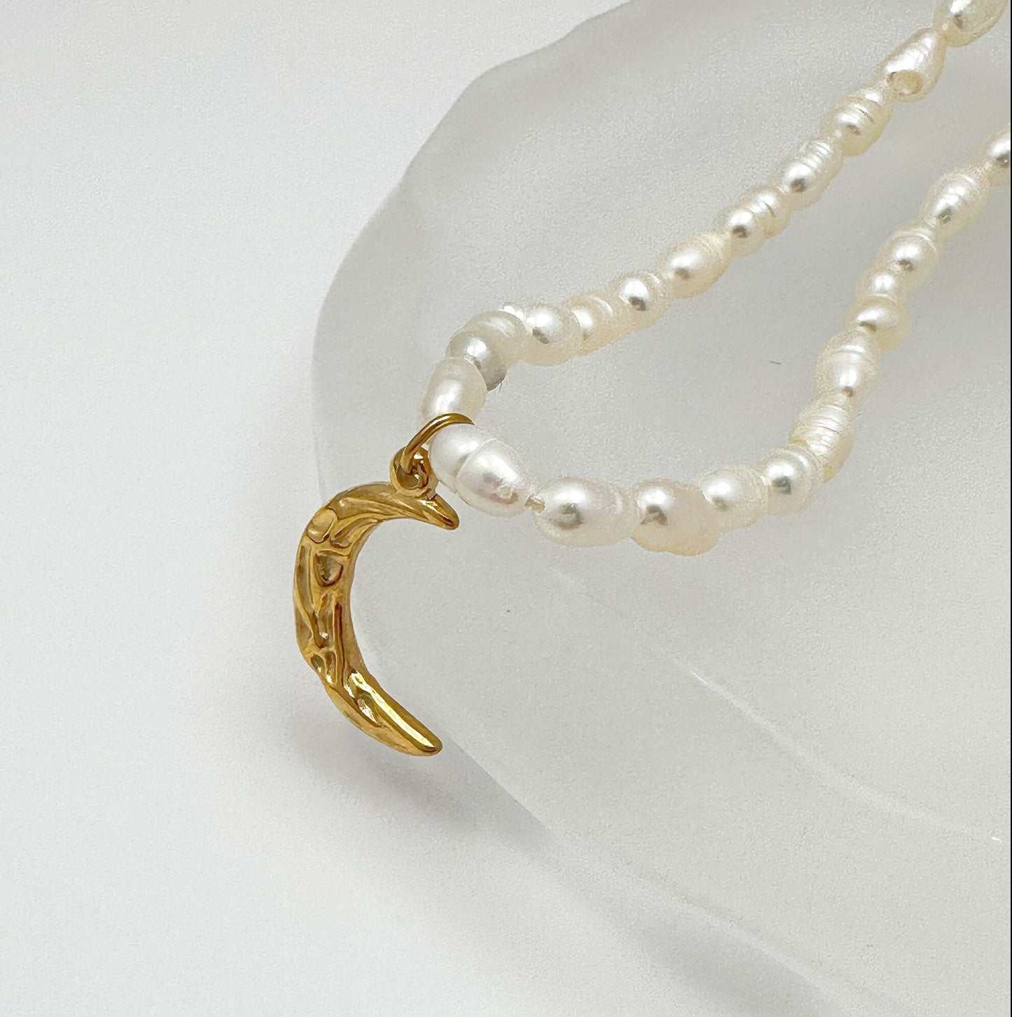 Time-honored freshwater pearl necklace with a unique 18k gold plated crescent moon charm.