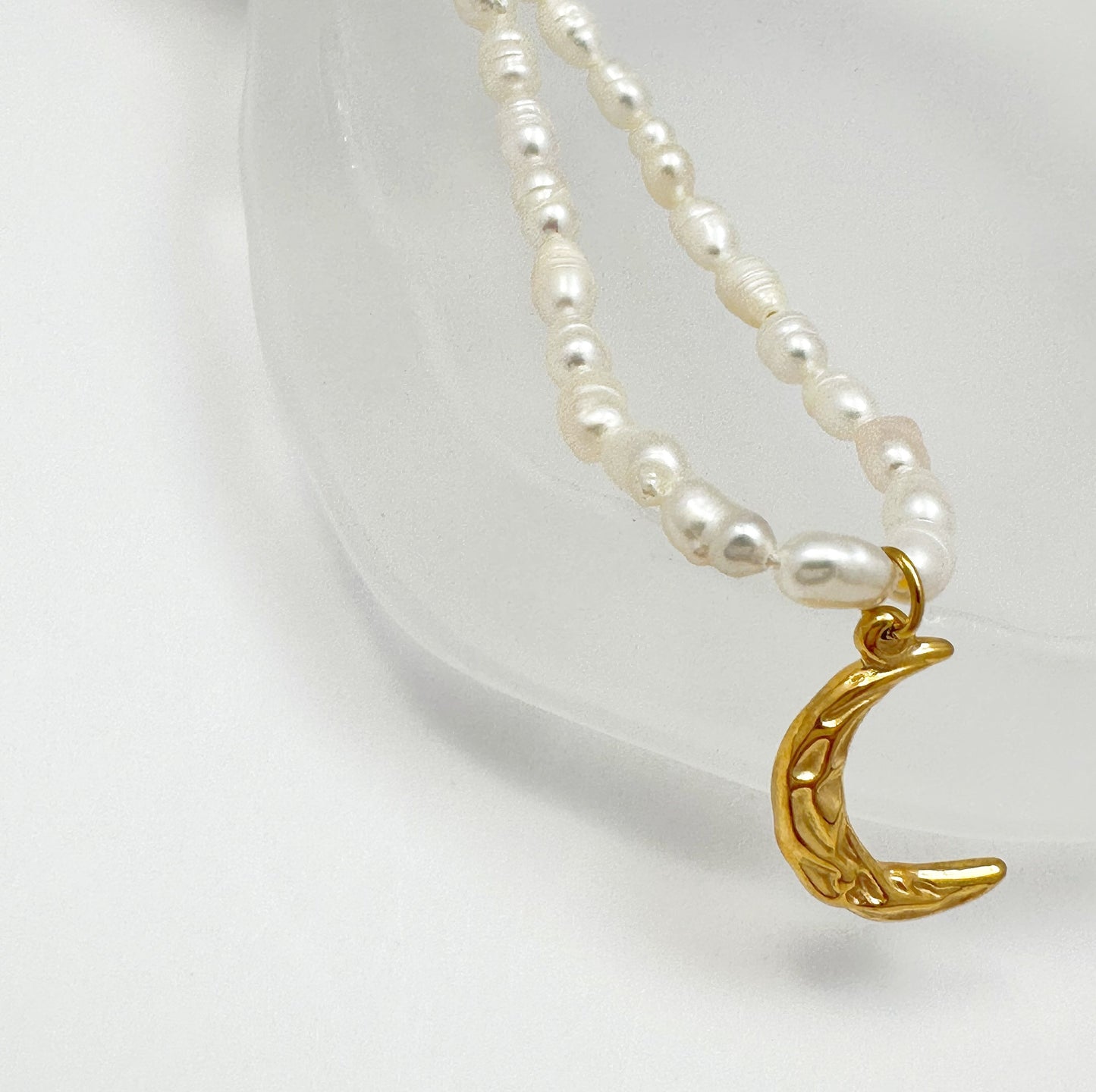 Time-honored freshwater pearl necklace with a unique 18k gold plated crescent moon charm.