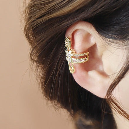 Gold plated ear cuff in a unique paper clip design, embellished with sparkling cubic zirconia, isolated on a white background