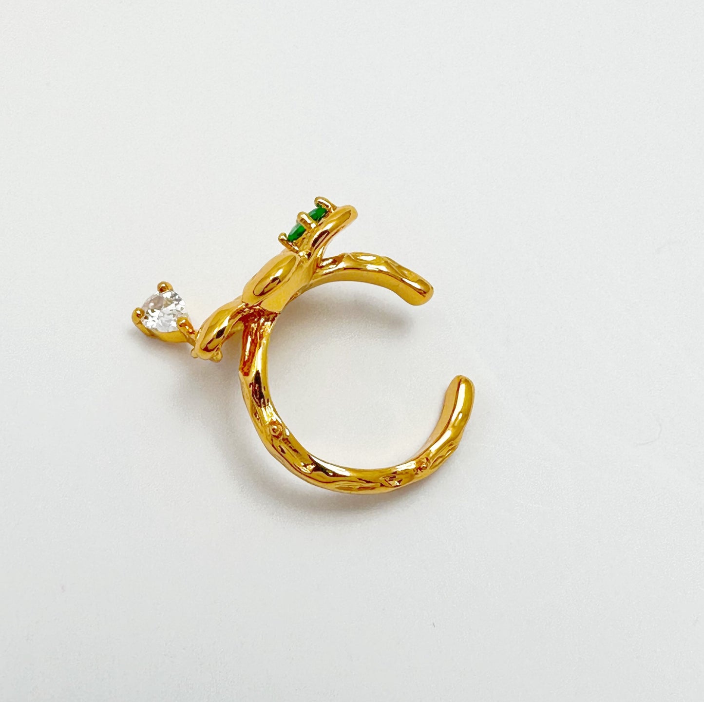 Elegant ear cuff with 18k gold plating, showcasing a bright green gemstone and delicate gemstone drop detail.