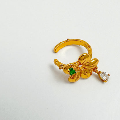 Elegant ear cuff with 18k gold plating, showcasing a bright green gemstone and delicate gemstone drop detail.