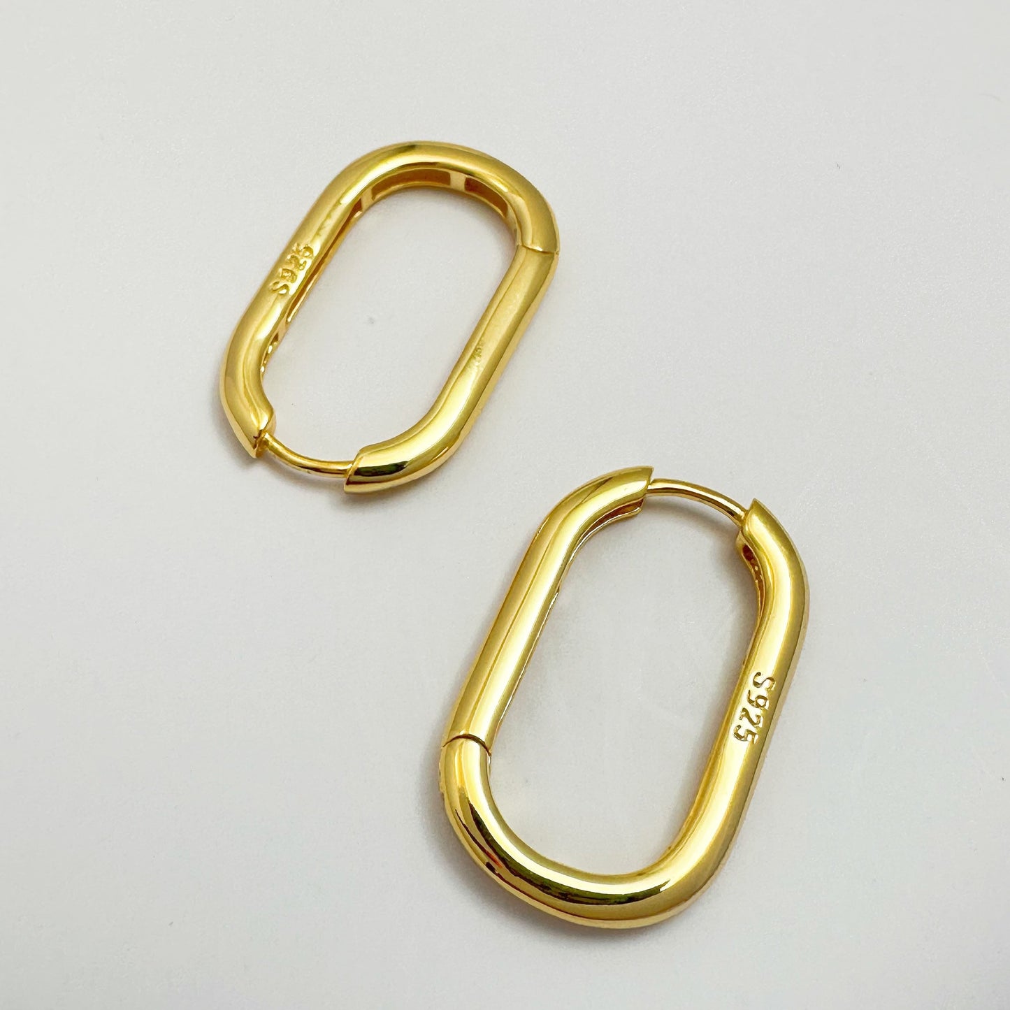 Contemporary s925 silver hoop earrings displayed on a white backdrop, highlighting the modern design.