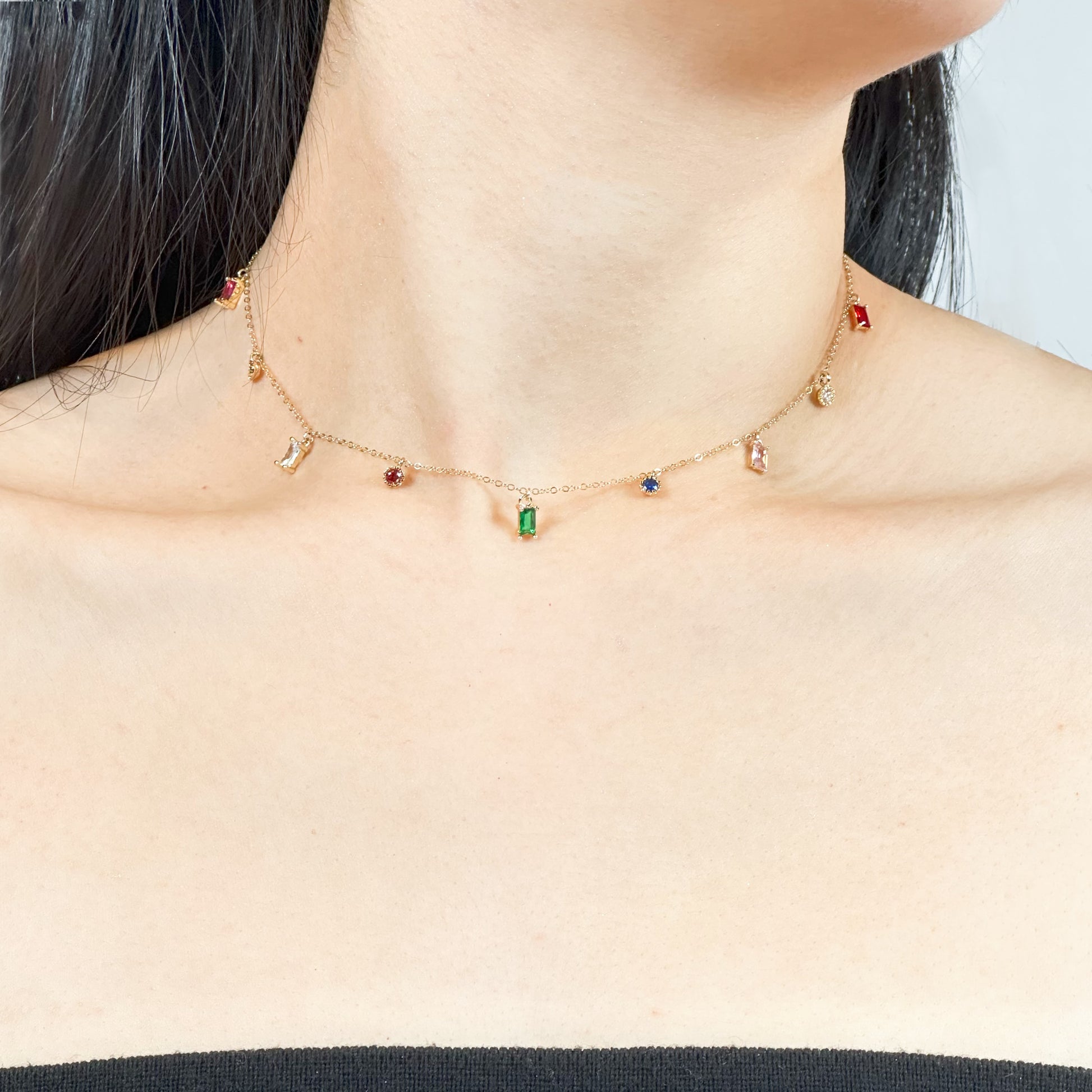 Gold-filled chain necklace adorned with multicolored zircon gemstones in green, red, blue, and purple.