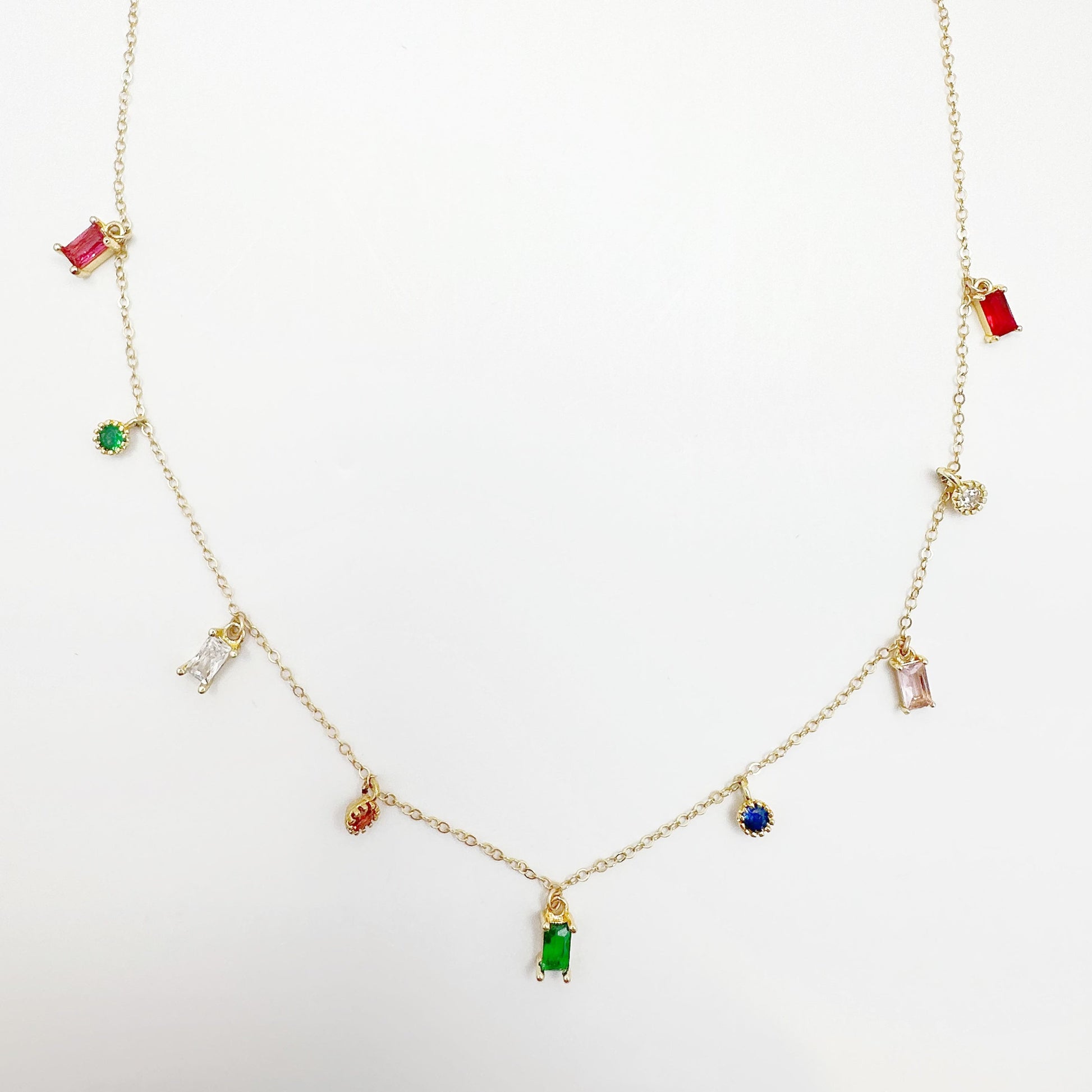 Gold-filled chain necklace adorned with multicolored zircon gemstones in green, red, blue, and purple.