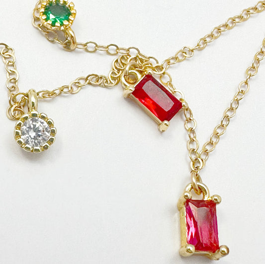 Gold-filled chain necklace adorned with multicolored zircon gemstones in green, red, blue, and purple.