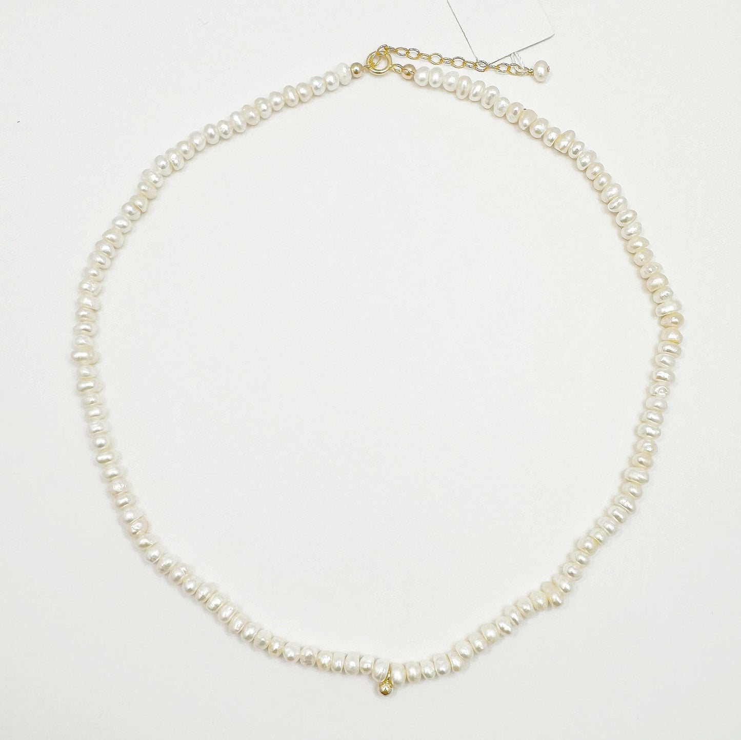 Timeless natural pearl necklace with a distinctive gold-filled ball in the center