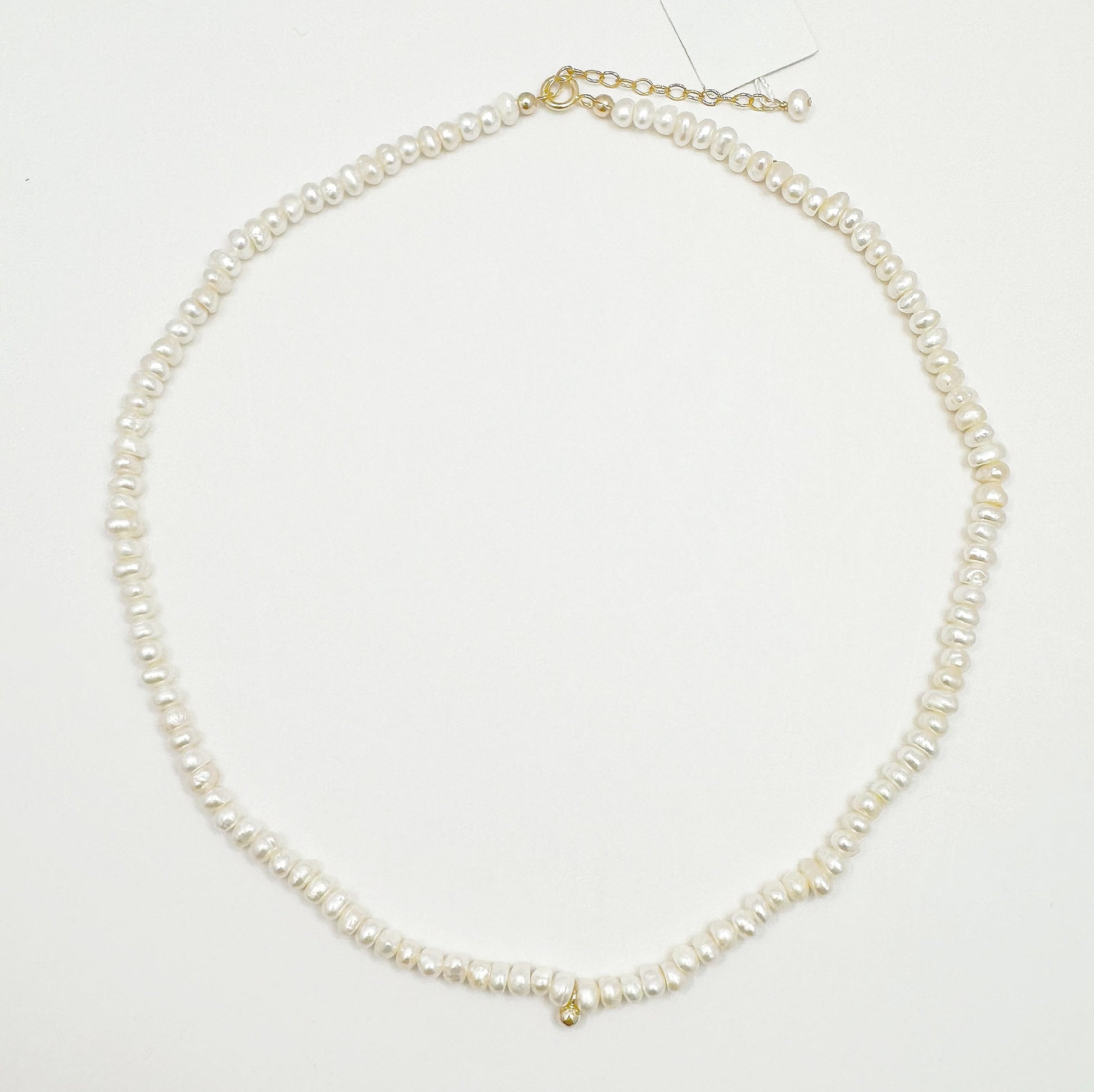 Timeless natural pearl necklace with a distinctive gold-filled ball in the center