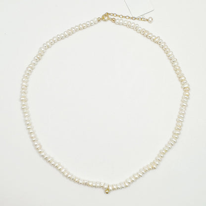 Timeless natural pearl necklace with a distinctive gold-filled ball in the center