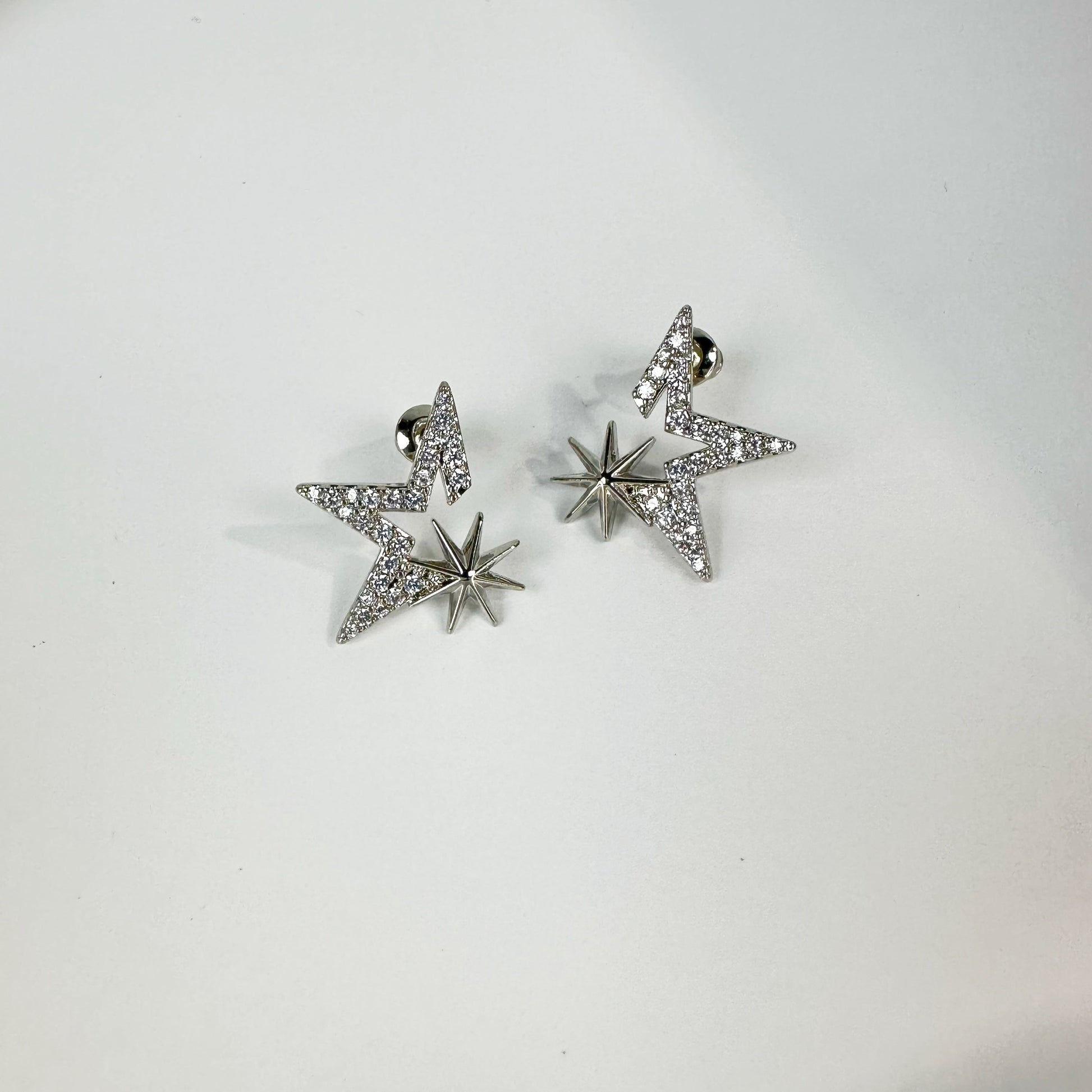 Kiss the Stars Earrings, which are elegantly crafted from white gold plated over brass, featuring a star-shaped design with sparkling accents.