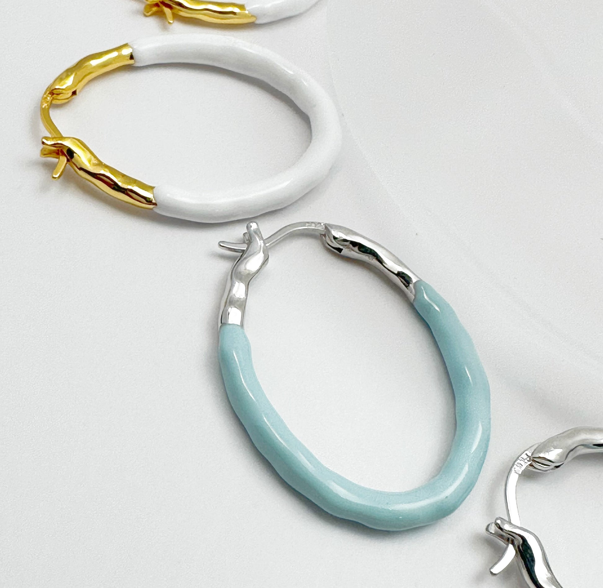 Gold Vermeil hoop earrings with a pastel blue dripping glaze finish.