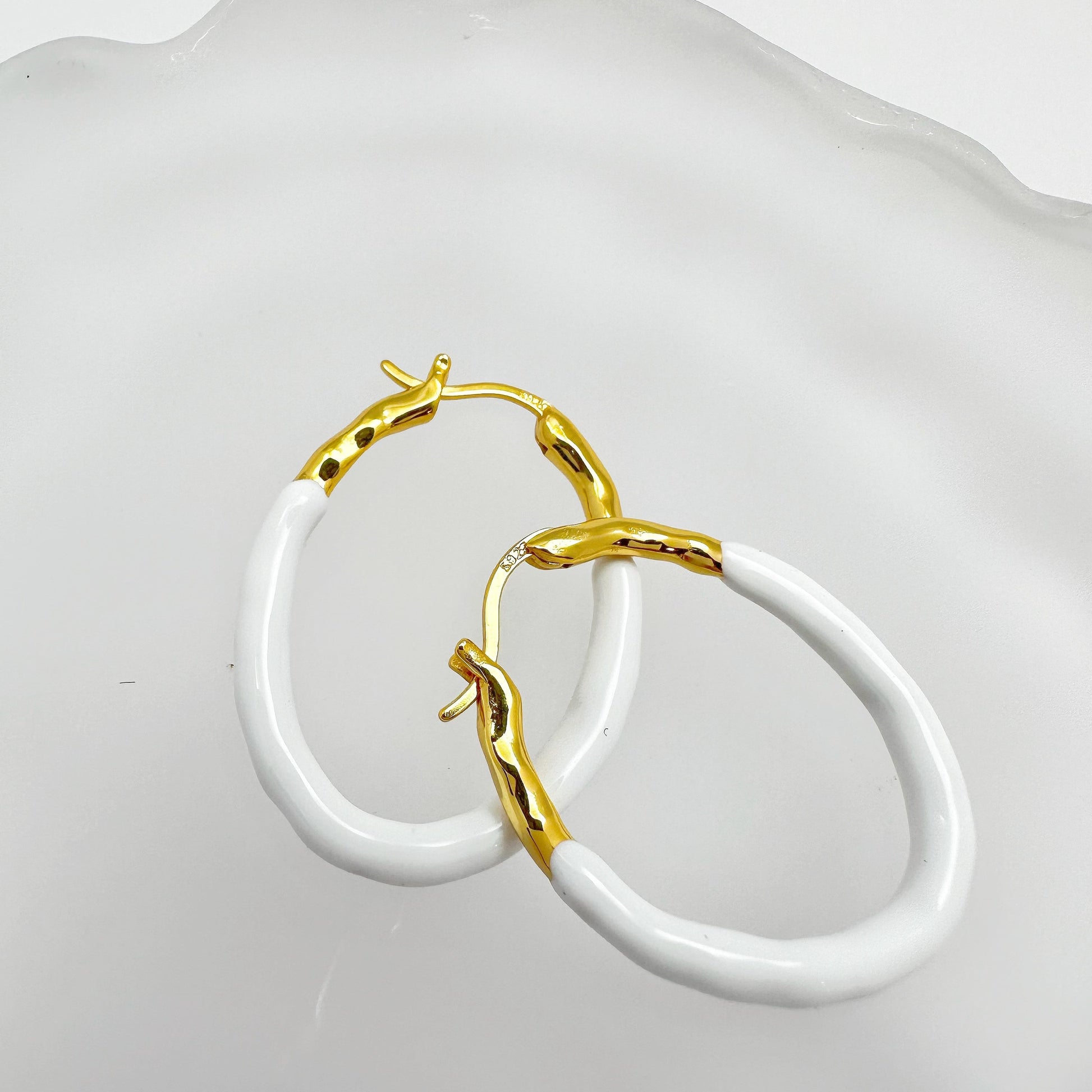 Gold Vermeil hoop earrings with a pastel blue dripping glaze finish.