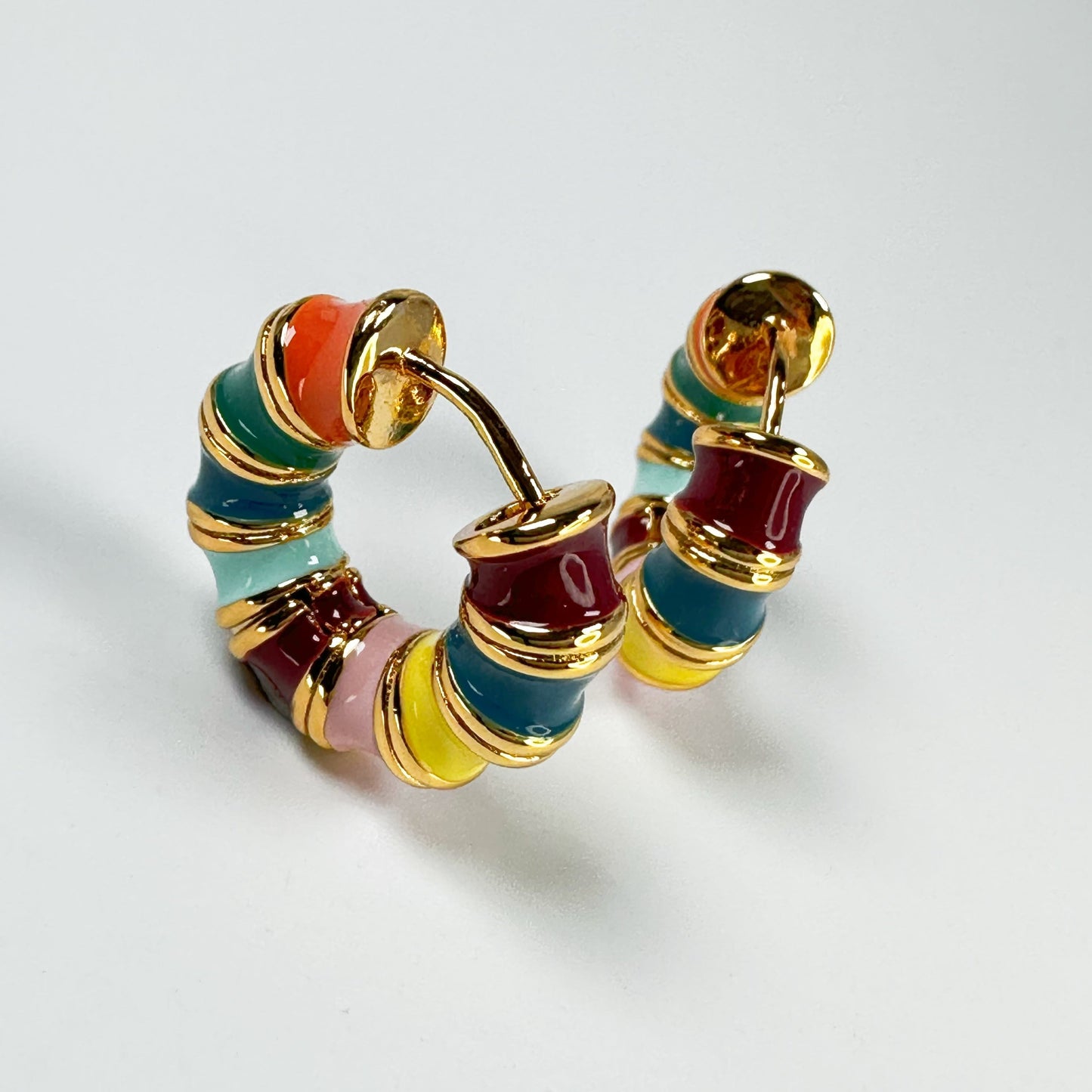 Rainbow Hoop Earrings in 18k gold plating featuring a vibrant array of enamel colors presented on a clear background.