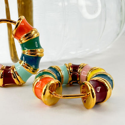 Rainbow Hoop Earrings in 18k gold plating featuring a vibrant array of enamel colors presented on a clear background.