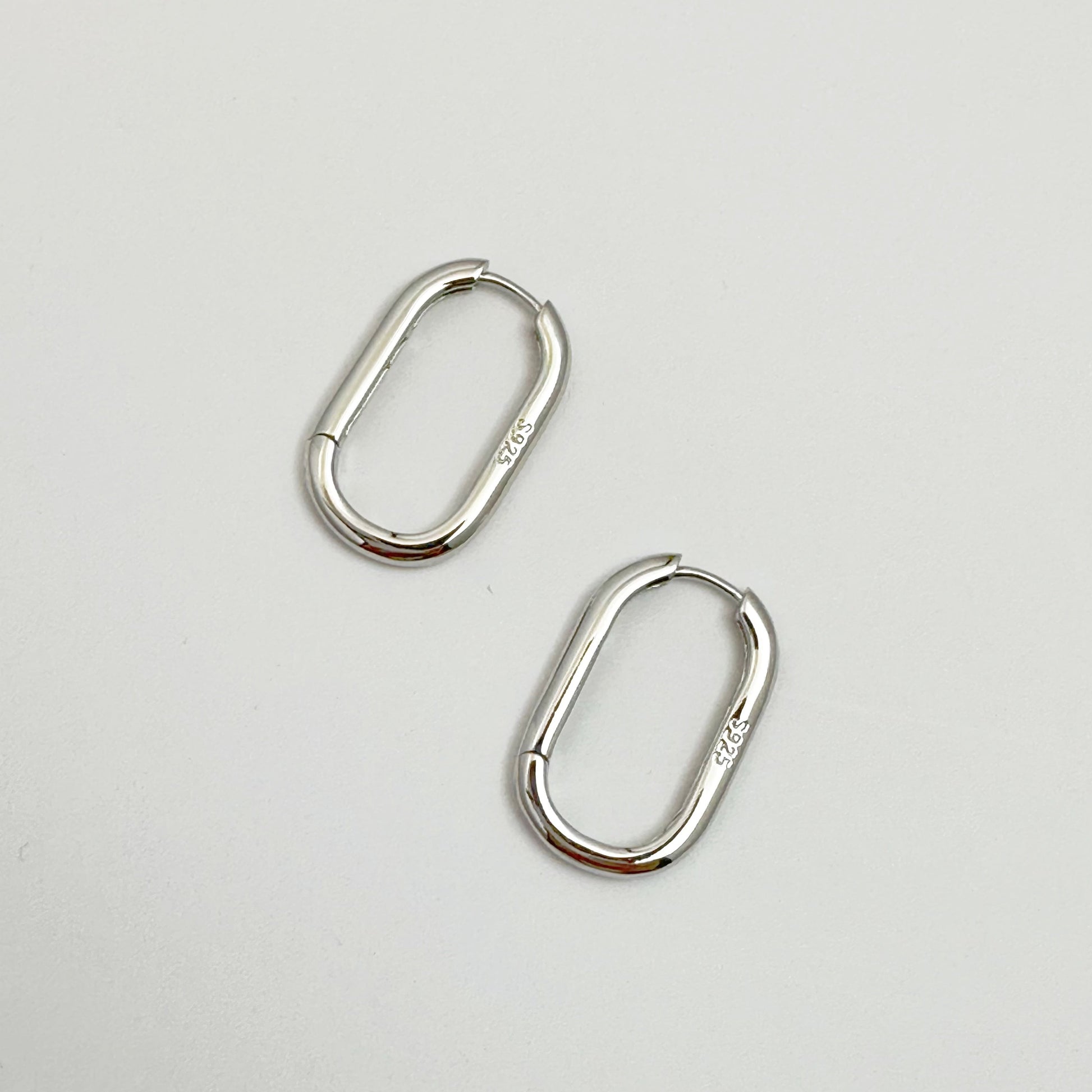 Contemporary s925 silver hoop earrings displayed on a white backdrop, highlighting the modern design.