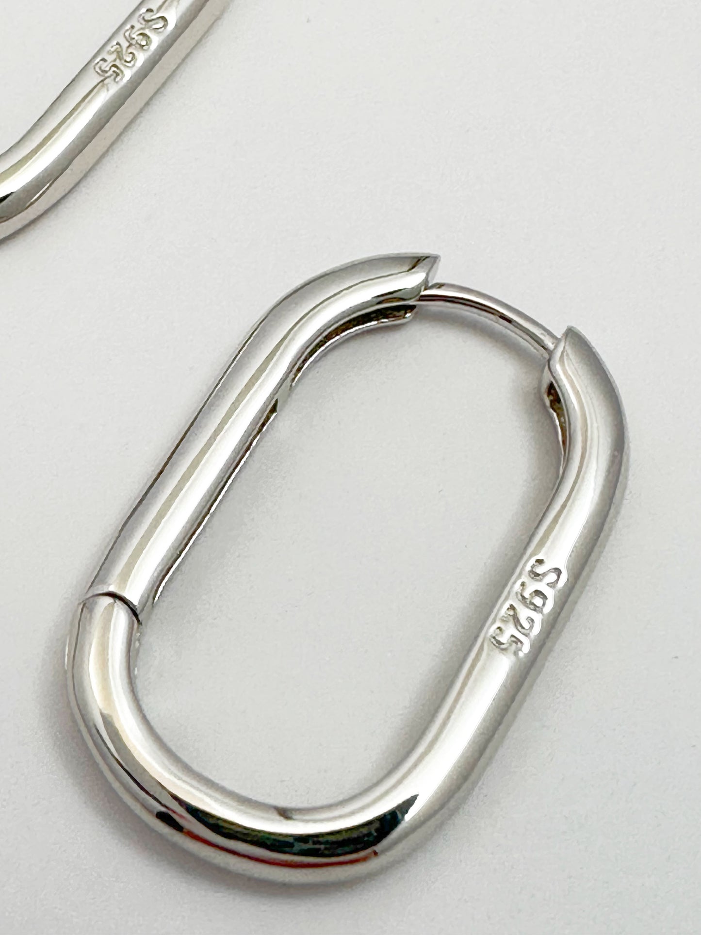 Contemporary s925 silver hoop earrings displayed on a white backdrop, highlighting the modern design.