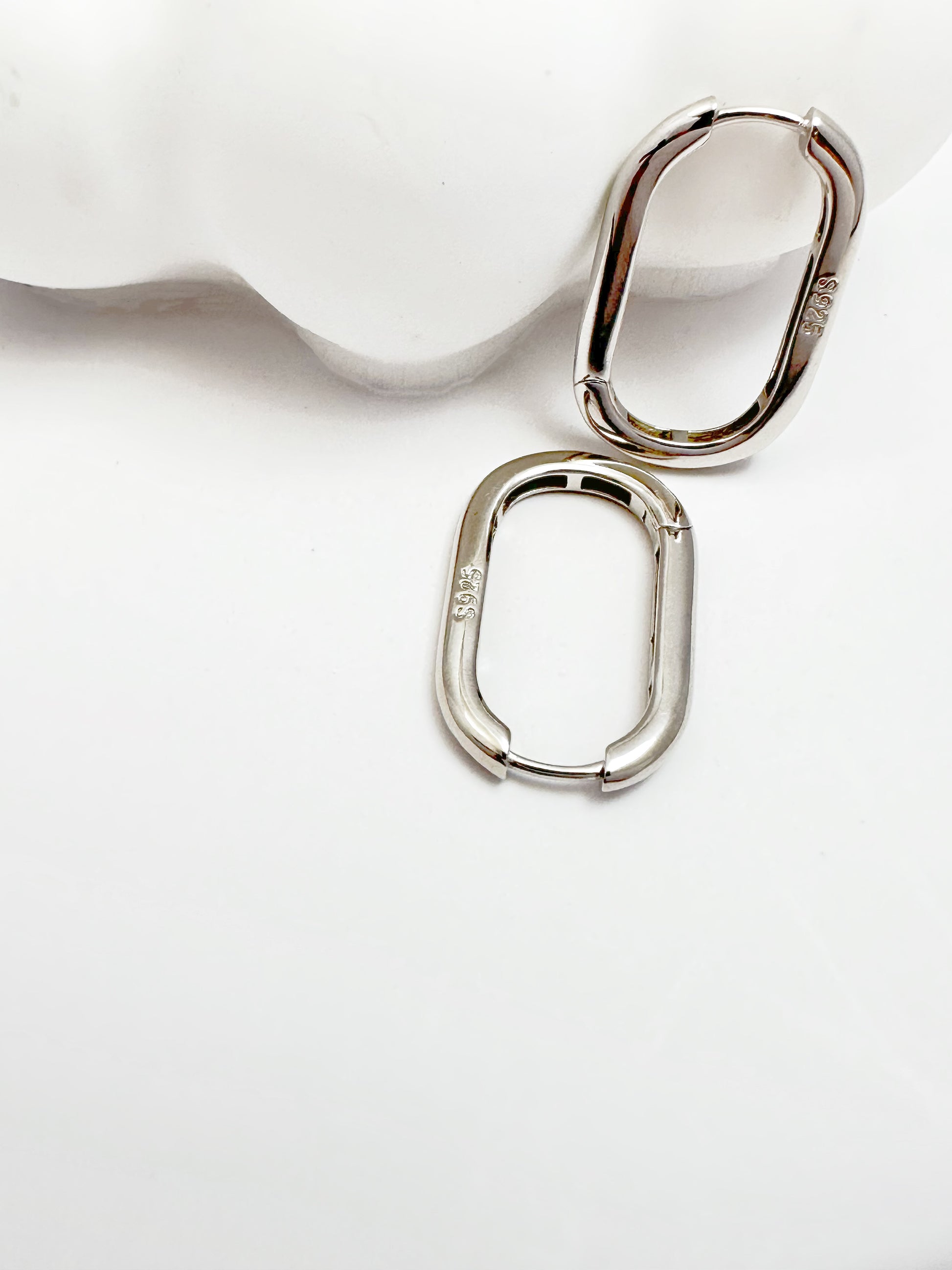 Contemporary s925 silver hoop earrings displayed on a white backdrop, highlighting the modern design.