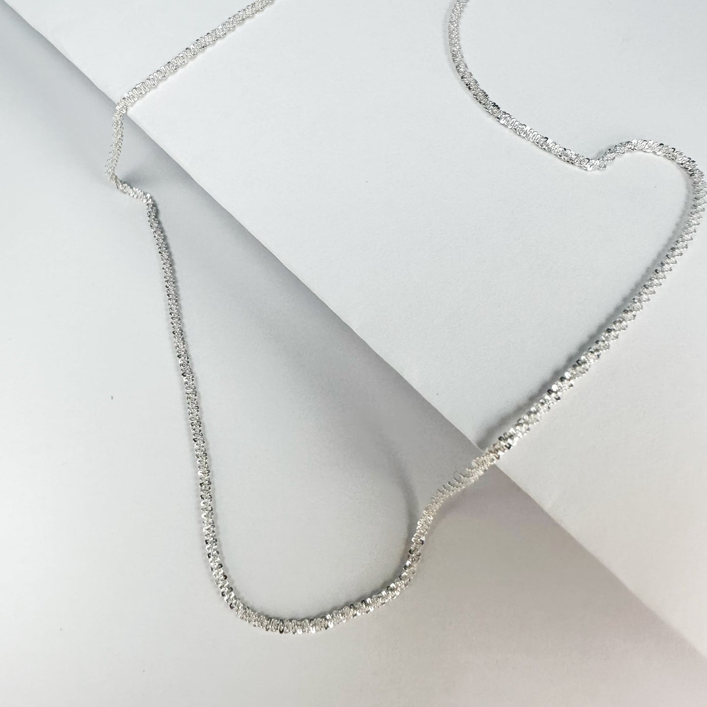 Sparkling S925 sterling silver necklace displayed on a neutral backdrop, showcasing a classic and elegant design